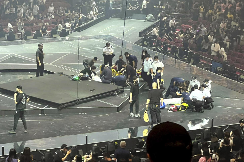 CORRECTS DATE - Two dancers receive medical treatment at a concert of Cantopop boy band Mirror, in Hong Kong, Thursday, July 28, 2022. Two dancers were injured at a Cantopop concert in Hong Kong after a massive video screen suspended above the stage fell onto performers below. (AP Photo)