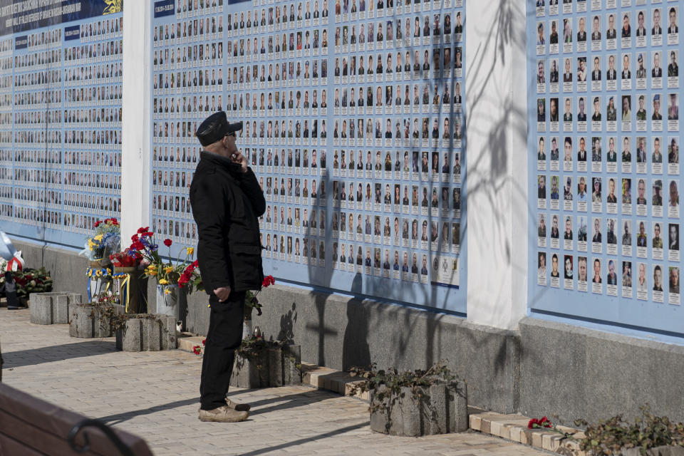 A woman watches the Memory Wall of Fallen Defenders of Ukraine in Russian-Ukrainian War on Ukrainian Volunteer Day in Kyiv, Ukraine, Tuesday, March 14, 2023. (AP Photo/Andrew Kravchenko)