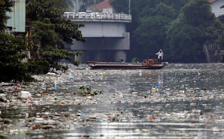 FILE PHOTO: Residents manoeuvre a boat, as a team from the governmental Pasig River Rehabilitation Commission and Greenpeace activists (not pictured) inspect the polluted Pasig River in San Juan, Metro Manila, Philippines September 8, 2017. REUTERS/Erik De Castro