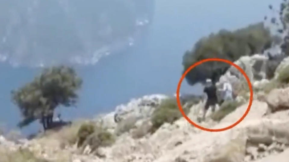 The woman and her husband are seen on the clifftop in Turkey. Source: Atv Haber