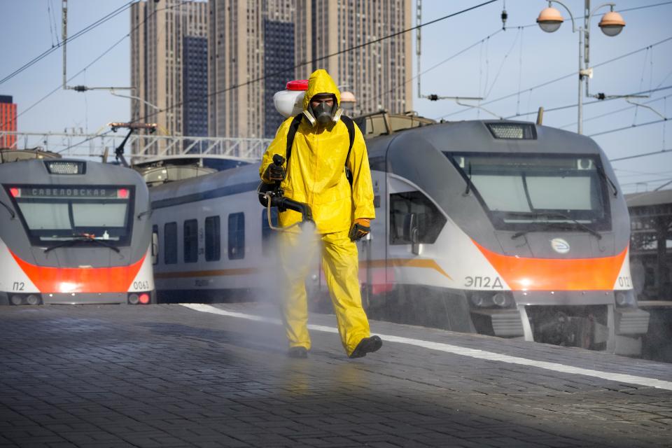 An employee of the Federal State Center for Special Risk Rescue Operations of Russia Emergency Situations disinfects a platform of Savyolovsky railway station in Moscow, Russia, Tuesday, Oct. 26, 2021. The daily number of COVID-19 deaths in Russia hit another high Tuesday amid a surge in infections that forced the Kremlin to order most Russians to stay off work starting this week. (AP Photo/Alexander Zemlianichenko)