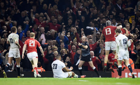 Rugby Union - Six Nations Championship - Wales v England - Principality Stadium, Cardiff, Britain - February 23, 2019 The touch judge gestures as Wales' Josh Adams celebrates with team mates after scoring their second try REUTERS/Rebecca Naden