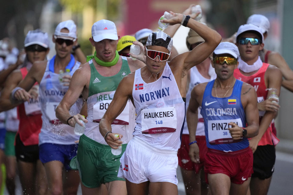 Havard Haukenes, center, of Norway competes during the men's 50km race walk at the 2020 Summer Olympics, Friday, Aug. 6, 2021, in Sapporo, Japan. (AP Photo/Shuji Kajiyama)