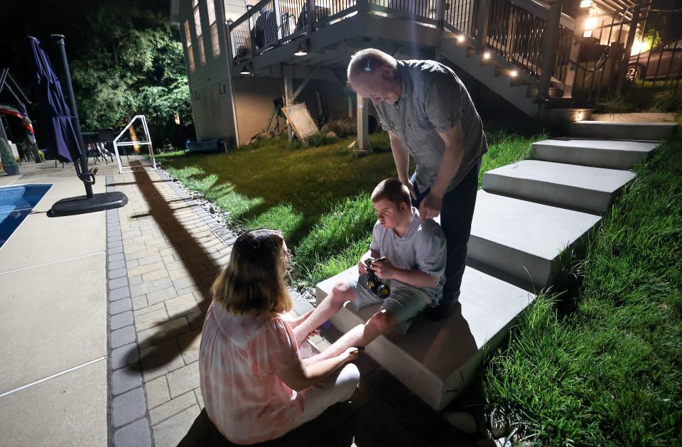 Annette Maughan and Glenn Maughan help comfort their son Glenn Maughan, nicknamed Bug, as Bug recovers from a tonic seizure outside of their home in Manchester, Md., on Saturday, July 8, 2023. Bug, age 20, currently experiences one to three seizures a day. | Kristin Murphy, Deseret News