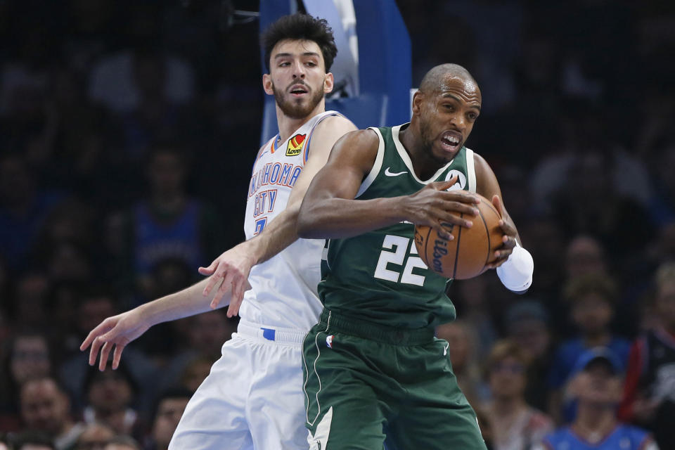Milwaukee Bucks forward Khris Middleton (22) grabs a rebound in front of Oklahoma City Thunder forward Chet Holmgren, left, during the first half of an NBA basketball game Friday, April 12, 2024, in Oklahoma City. (AP Photo/Nate Billings)