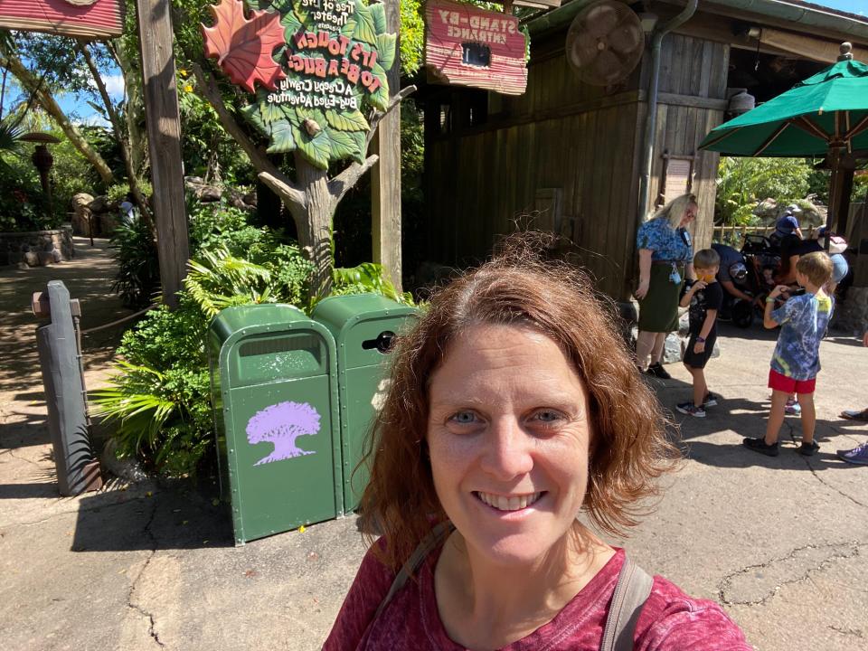 kari posing for a selfie in front of the its tough to be a bug queue entrance at animal kingdom
