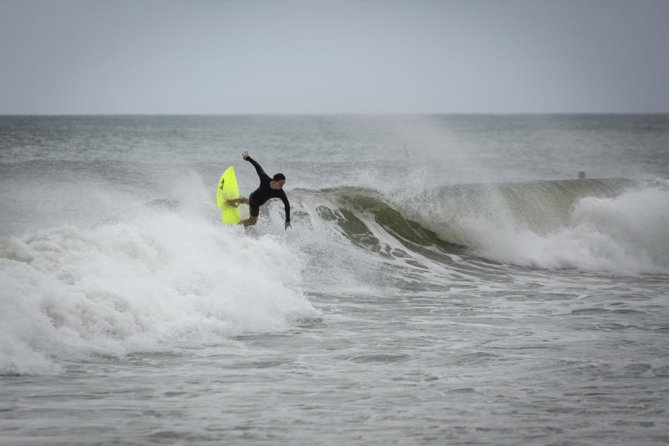 A surfer rides a wave in Deerfield Beach, Florida, on Sept. 3, 2019, as Hurricane Dorian moves closer to Florida.  / Credit: EVA MARIE UZCATEGUI/AFP via Getty Images