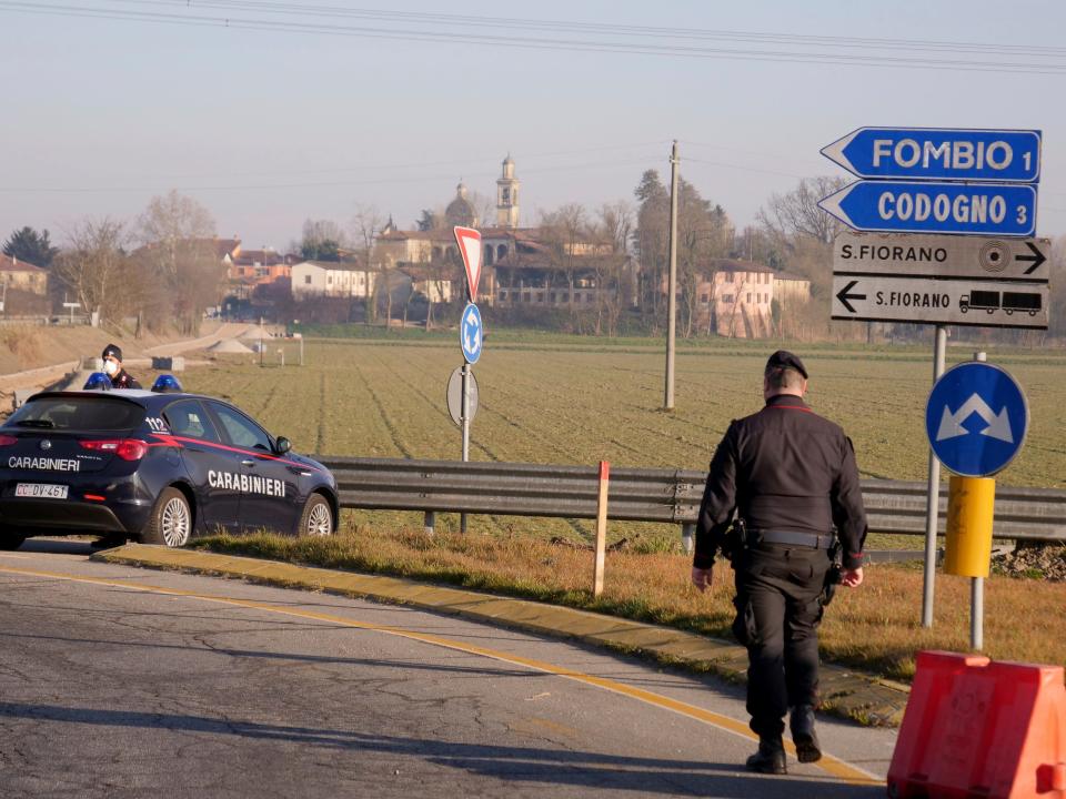 Carabinieri (Italian paramilitary police) officers set a road block in Codogno, Northern Italy, Monday, Feb. 24, 2020. Italy scrambled to check the spread of Europe's first major outbreak of the new viral disease amid rapidly rising numbers of infections and a third death. Road blocks were set up in at least some of 10 towns in Lombardy at the epicenter of the outbreak, to keep people from leaving or arriving. (AP Photo/Paolo Santalucia)
