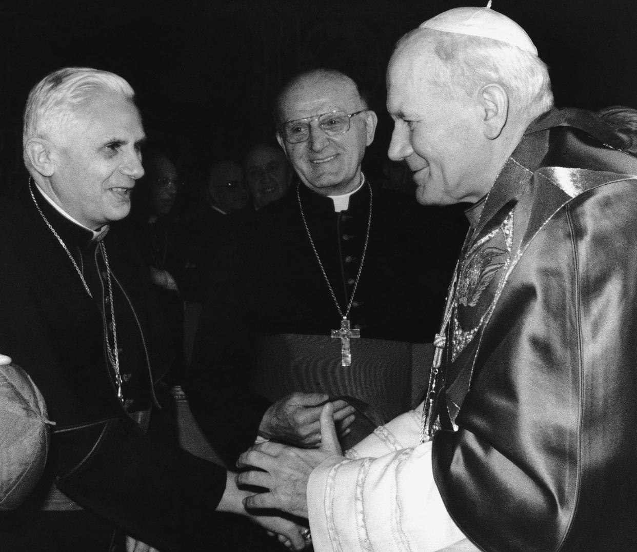 FILE - Pope John Paul II, right, shakes hands with Cardinal Joseph Ratzinger, prefect of the Congregation for the Doctrine of the Faith, during Christmas greetings in the Clementine Hall at the Vatican on Dec. 20, 1985. Ratzinger went on to become Pope Benedict XVI. Pope Emeritus Benedict XVI, the German theologian who will be remembered as the first pope in 600 years to resign, has died, the Vatican announced Saturday. He was 95. (AP Photo/Massimo Sambucetti, File)