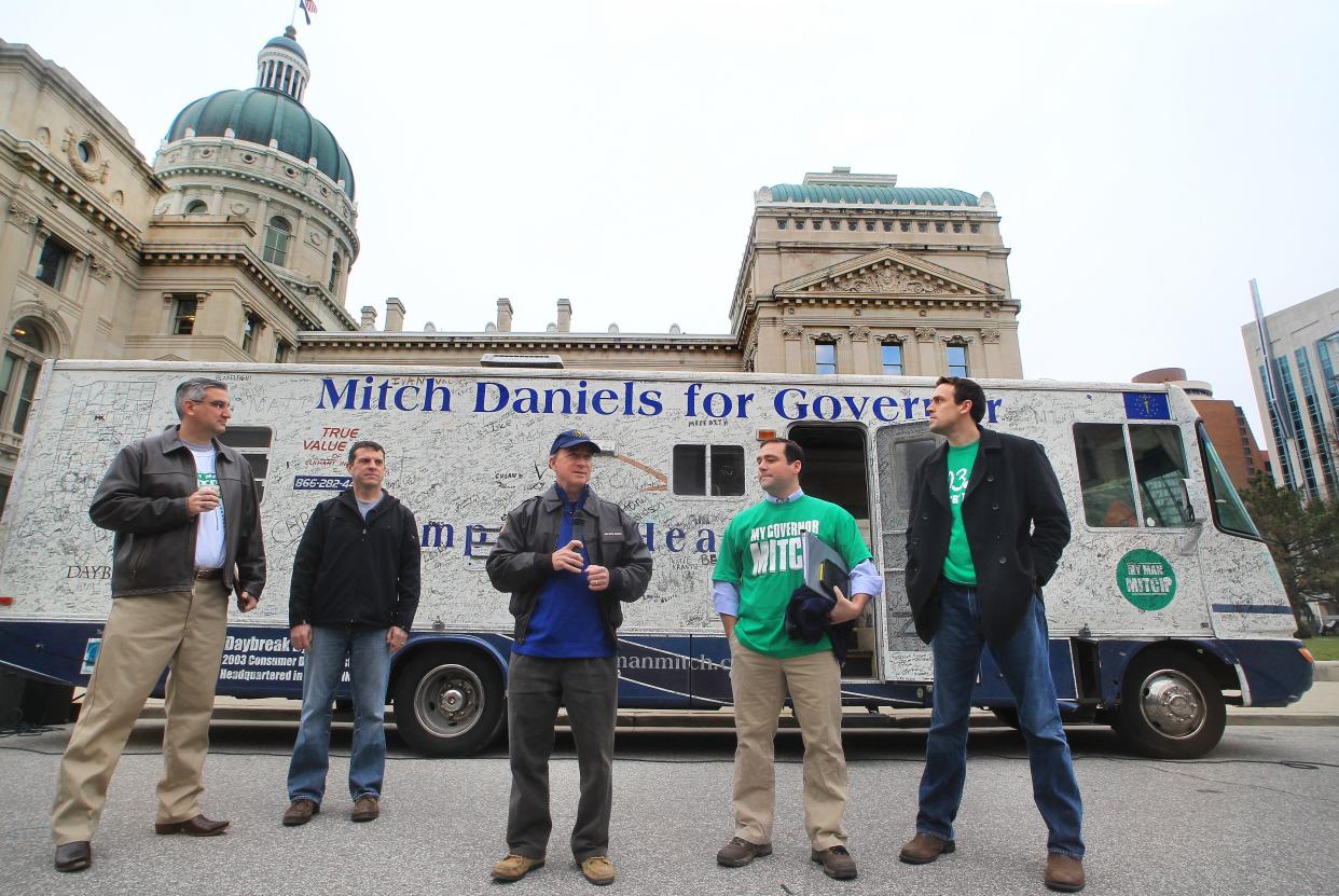 Indiana Gov. Mitch Daniels, center, makes comments before leaving the Statehouse to deliver R.V. One, the recreational vehicle he crisscrossed the state in during his successful 2004 and 2008 gubernatorial campaigns, before making the trip to Elkhart to deliver the RV to the RV Hall of Fame on Wednesday, Dec. 19, 2012. The RV, with 85,000 miles on it, had been sitting in a barn and has now been donated to the Indiana State Museum. It will be on display while on loan to the Hall of Fame. Shown left to right are Indiana Republican Party Chairman Eric Holcomb; Bill Oesterle, who came up with the idea of R.V. One; Daniels; and Ben Ledo and Adam Horst, who shared R.V. One driving responsibilities during the campaign. Charlie Nye / The Star.