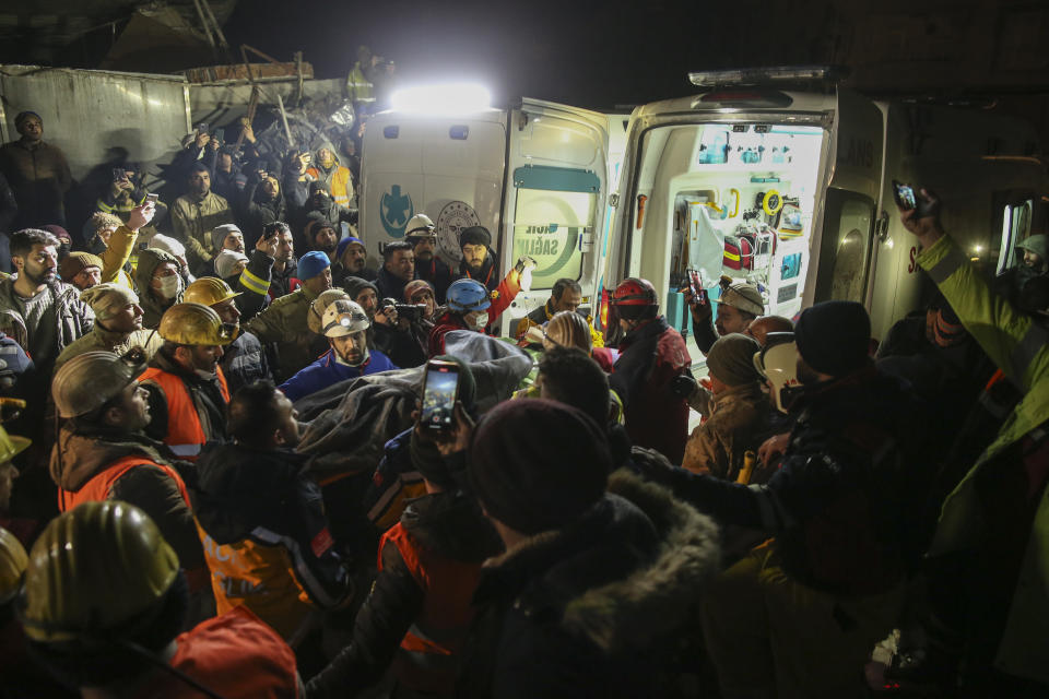 Rescue workers pull out a young woman from a collapsed building in Adiyaman, southern Turkey, Thursday, Feb. 9, 2023. Thousands who lost their homes in a catastrophic earthquake huddled around campfires and clamored for food and water in the bitter cold, three days after the temblor and series of aftershocks hit Turkey and Syria. (AP Photo/Emrah Gurel)