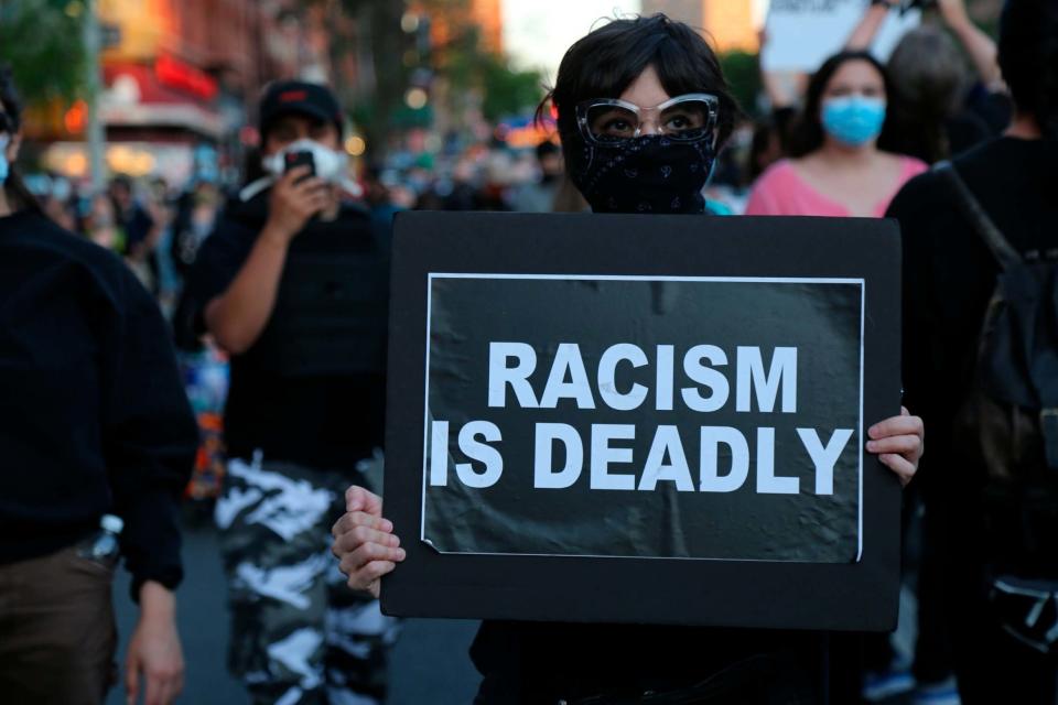 Protesters march down a street during a solidarity rally for George Floyd, Sunday, May 31, 2020, in the Brooklyn borough of New York (AP)