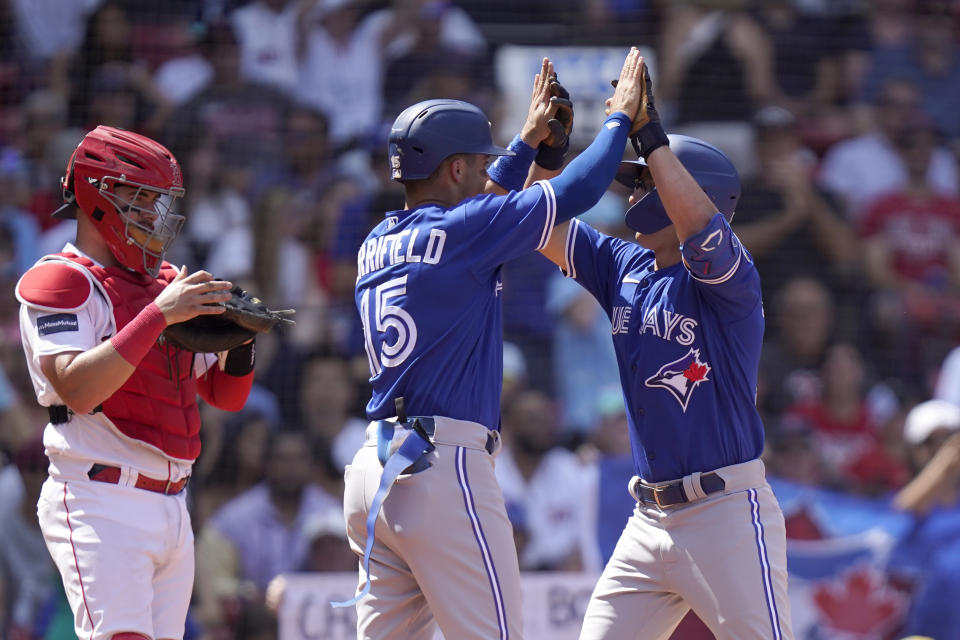 Toronto Blue Jays' Davis Schneider, right, celebrates after his two-run home run with Whit Merrifield, center, after they scored as Boston Red Sox's Reese McGuire, left, looks on in the fourth inning of a baseball game, Sunday, Aug. 6, 2023, in Boston. (AP Photo/Steven Senne)