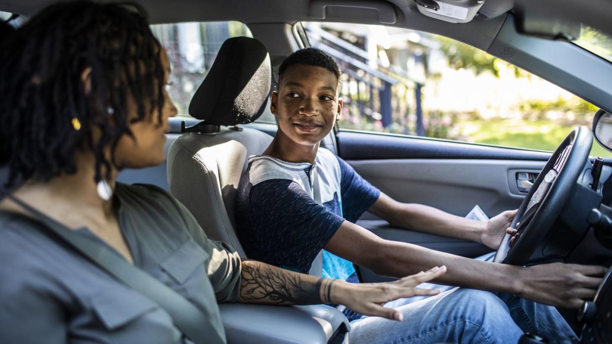 mother teaching teenage son to drive