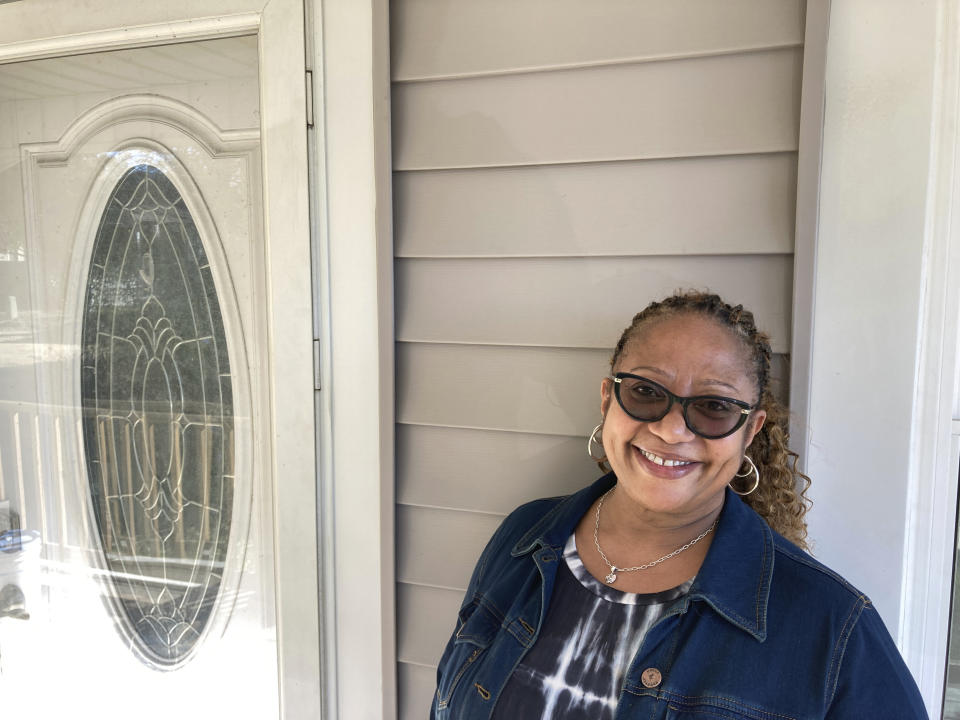 Karen Speights stands on the porch of her 1920s craftsman house in Norfolk, Va., Friday Oct. 7, 2022. A contractor had replaced the historic home’s original pine floor after a flood and installed laminate flooring. (AP Photo/Ben Finley)