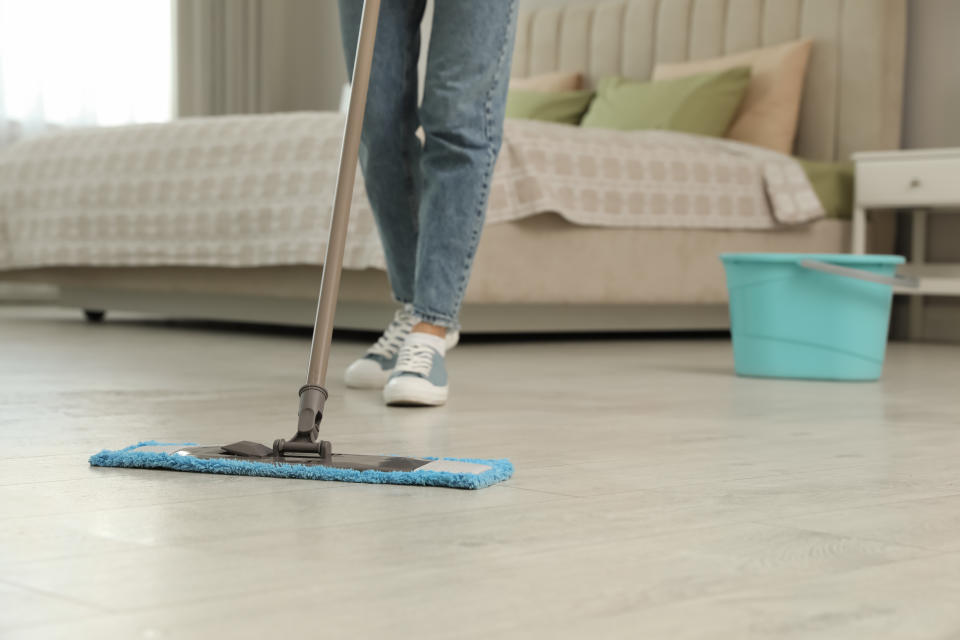 Woman cleaning floor with mop at home