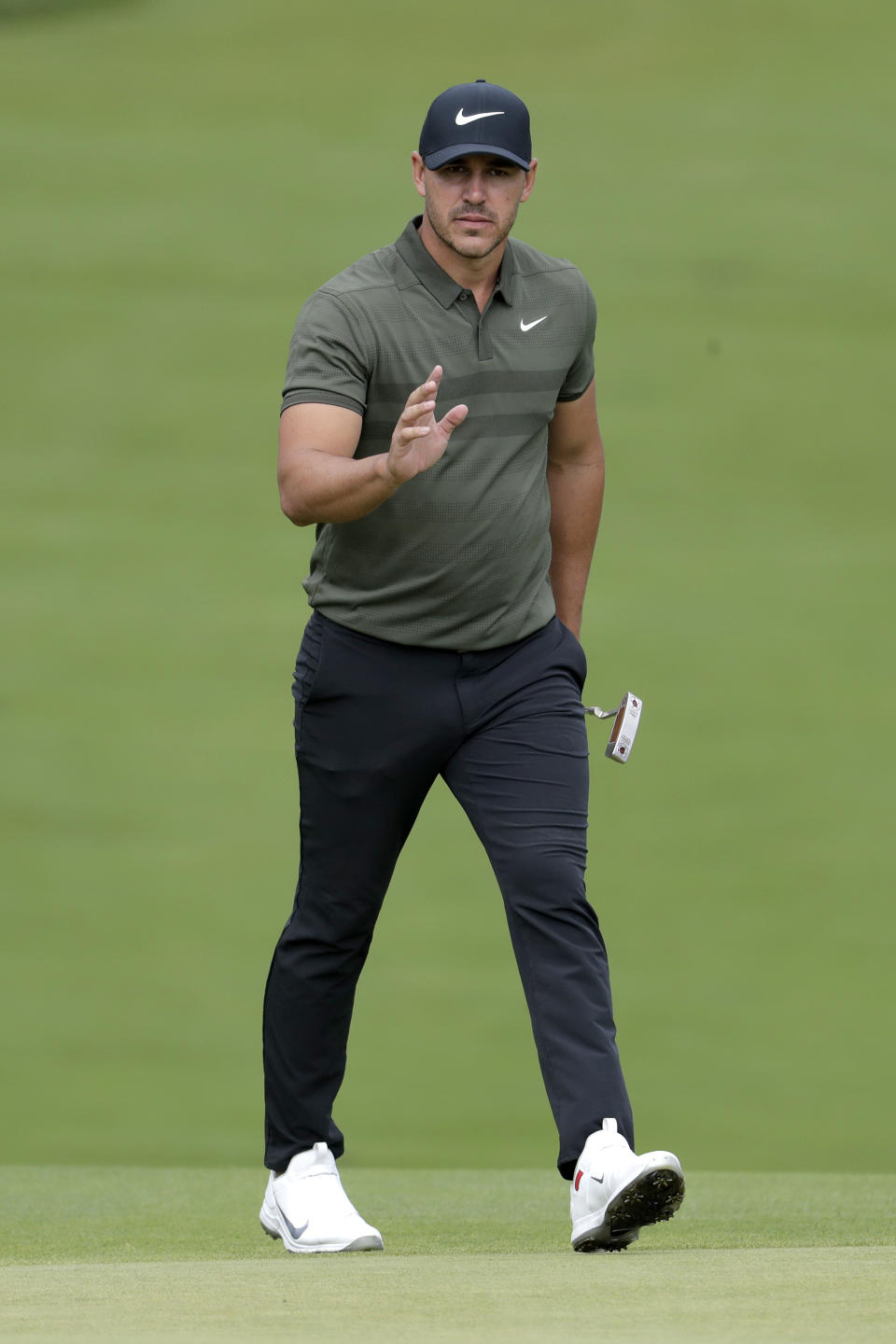 Brooks Koepka acknowledges the gallery after chipping on the 14th hole during the first round of the Northern Trust golf tournament, Thursday, Aug. 23, 2018, in Paramus, N.J. (AP Photo/Julio Cortez)
