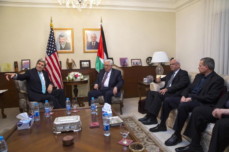 Secretary of State John Kerry, left, points out members of his staff to Palestinian President Mahmoud Abbas, Wednesday, March 26, 2014, at the Palestinian Ambassador’s Residence in Amman, Jordan. Kerry is attempting to salvage the Middle East peace talks as a breakdown looms. Second from right is Chief Palestinian Negotiator Saeb Erekat. (AP Photo/Jacquelyn Martin, Pool)