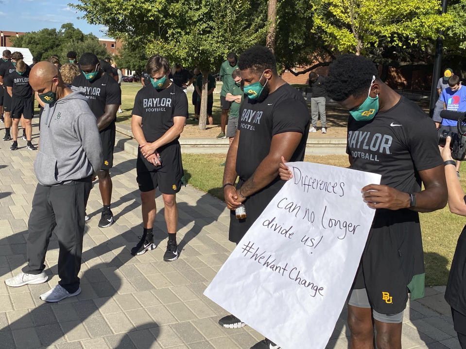 Members of the Baylor football team including Dave Aranda, left, bow their heads during a prayer after marching around campus, Thursday, Aug. 27, 2020, in Waco, Texas, protesting the shooting of Jacob Blake in Wisconsin. (Rod Aydelotte/Waco Tribune-Herald via AP)