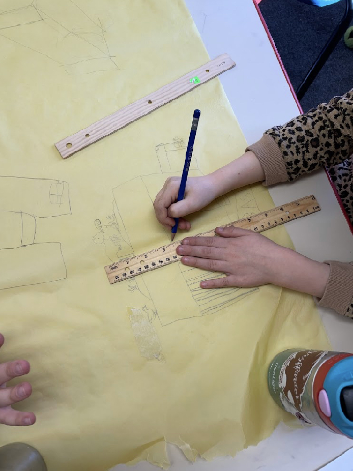 A Limestone Community School student in Lawrence, Kan., uses a ruler and pencil to trace a home design as part of a school project to build four homes in the city to help alleviate homelessness.