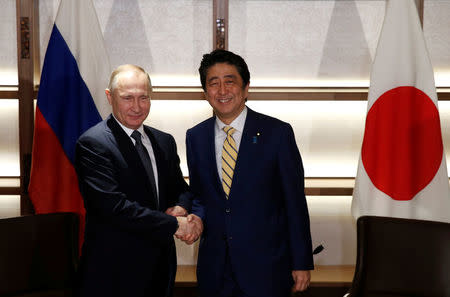 Russia's President Vladimir Putin (L) shakes hands with Japan's Prime Minister Shinzo Abe at the start of their summit meeting in Nagato, Yamaguchi prefecture, Japan, December 15, 2016. REUTERS/Toru Hanai