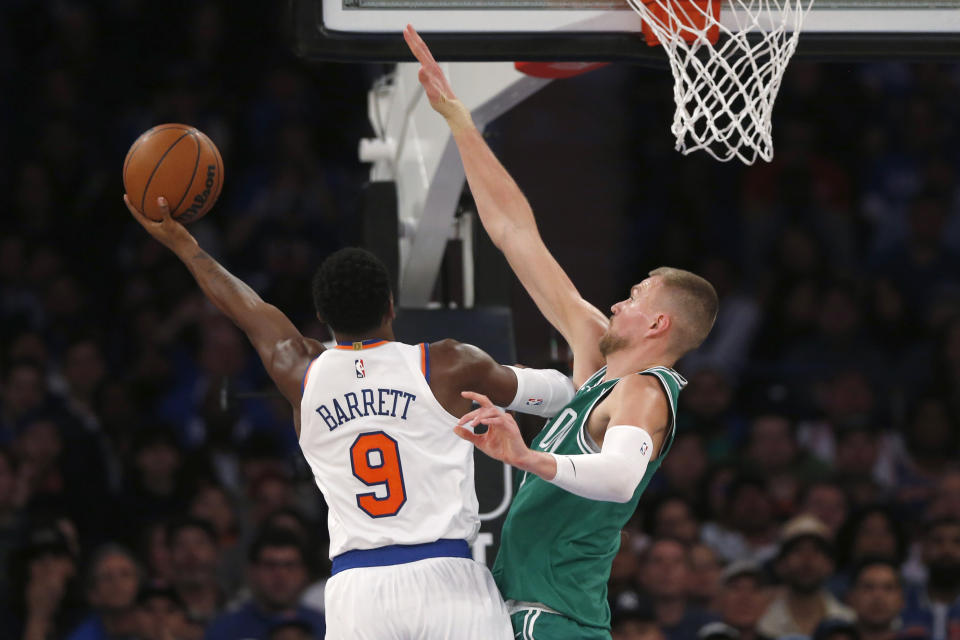 New York Knicks guard RJ Barrett (9) shoots over Boston Celtics center Kristaps Porzingis during the first half of an NBA basketball game Wednesday, Oct. 25, 2023, in New York. (AP Photo/John Munson)