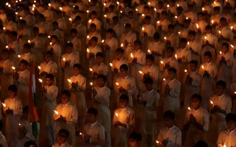 Students hold candles during a vigil for the dead paramilitary police - Credit: Reuters