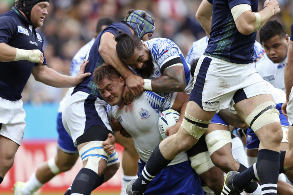 FILE - In this Oct. 10, 2015, file photo, Samoa's Jack Lam is tackled during their Rugby World Cup Pool B match between Samoa and Scotland at St James' Park, Newcastle, England. Samoan rugby players will wear skin suits to cover their traditional Pacific Islander tattoos during some training sessions at the World Cup in order not to offend their Japanese hosts. (AP Photo/Scott Heppell, File)