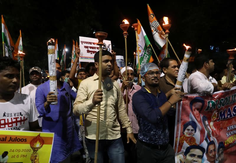 Supporters of India's main opposition Congress party carry torches as they attend a protest march against farm bills passed by India's parliament, in Kolkata