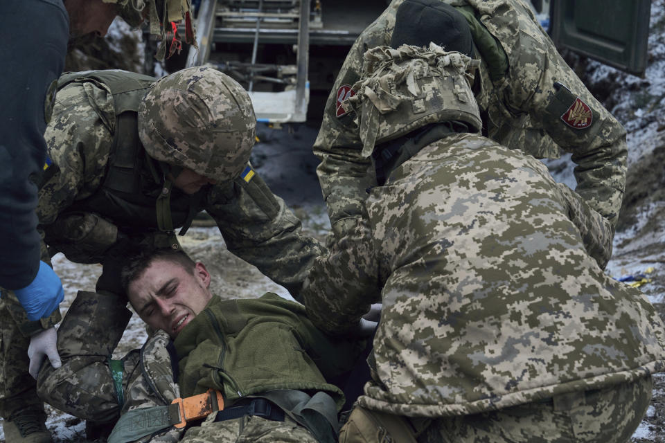 Military medics give first aid to a wounded soldier near Kremenna in the Luhansk region, Ukraine, Monday, Jan. 16, 2023. (AP Photo/LIBKOS)