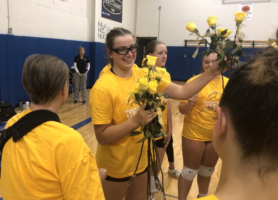 Brianna "Bri" Leitten is all smiles as her Bloomfield volleyball teammates present her with yellow roses in celebration of 10 years of being cancer free.