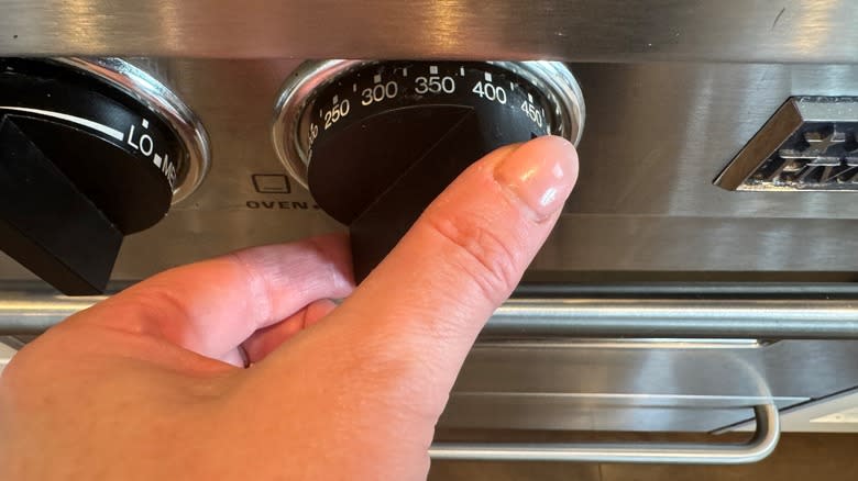 hand with oven dial