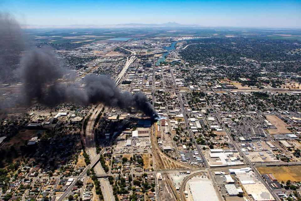 Plumes of black smoke hover over Stockton from a produce distribution warehouse behind the Growers Hall on Wilson Way and Channel Street in Stockton on Monday, June 20, 2022.