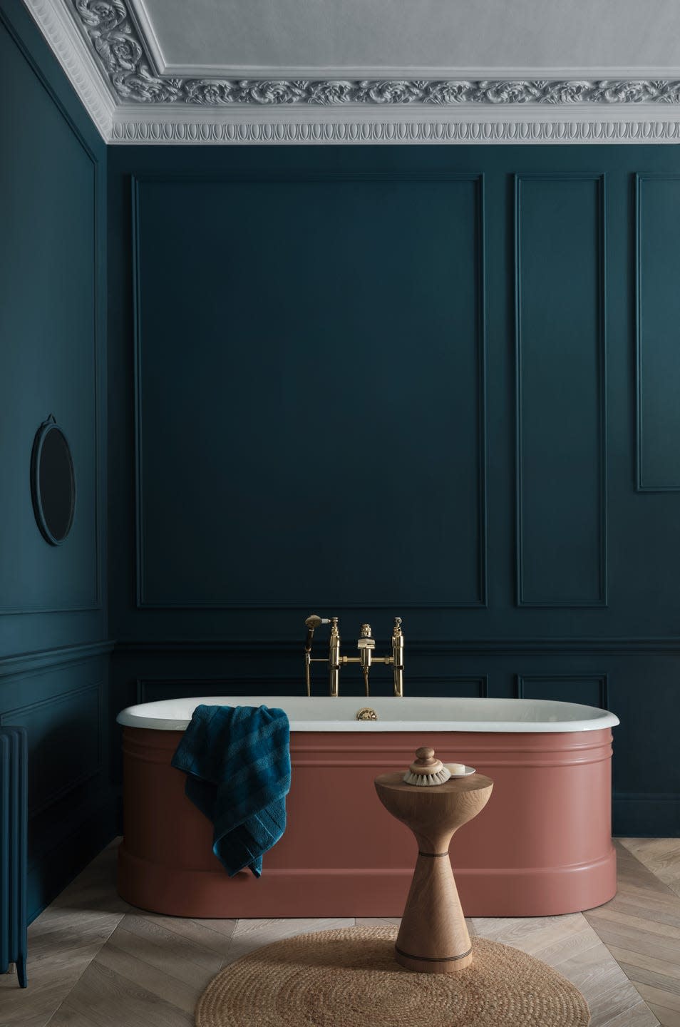 dark blue panelled bathroom with plaster pink freestanding bathtub