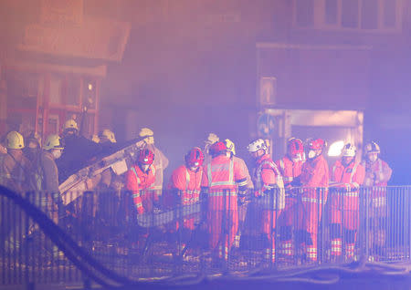 Members of the emergency services move debris at the site of an explosion which destroyed a convenience store and a home in Leicester, Britain, February 25, 2018. REUTERS/Darren Staples