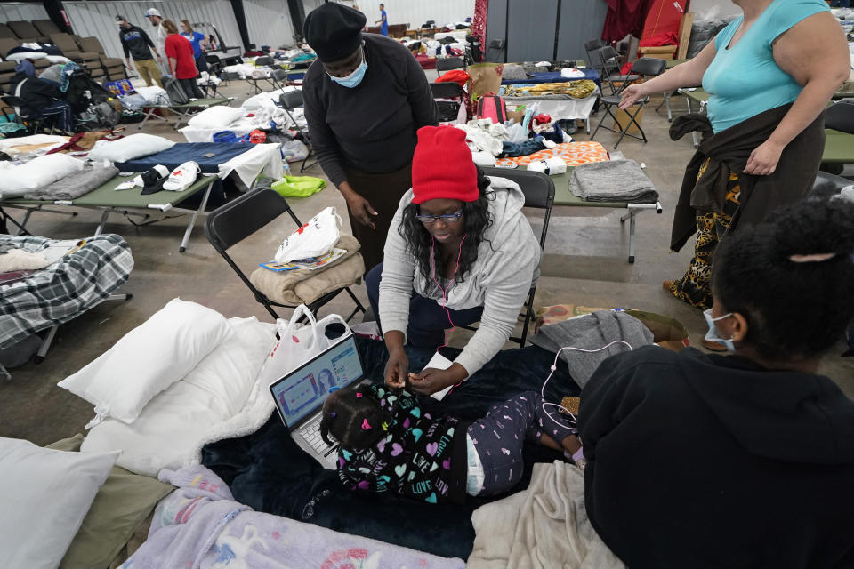 Angela Legat, a tornado victim, grooms her daughter Amara Legat, 5, in a shelter for the displaced, as they wait to be transported to better accommodations, in the aftermath of tornadoes that tore through the region, in Mayfield, Ky., Tuesday, Dec. 14, 2021. (AP Photo/Gerald Herbert)