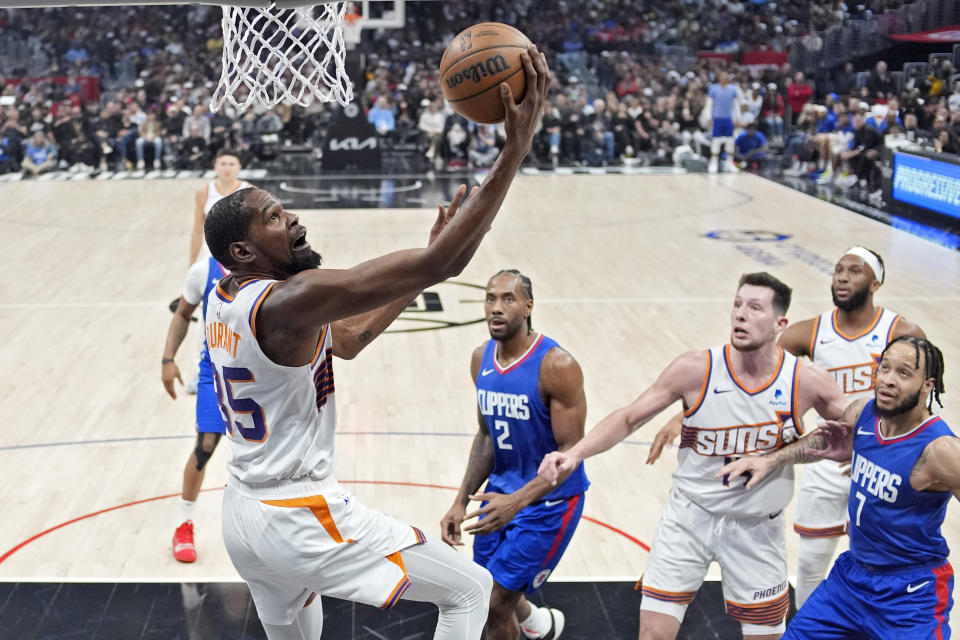 Phoenix Suns forward Kevin Durant (35) shoots as Los Angeles Clippers forward Kawhi Leonard (2) and guard Amir Coffey (7) defend while forward Drew Eubanks (14) and forward Josh Okogie watch during the first half of an NBA basketball game Monday, Jan. 8, 2024, in Los Angeles. (AP Photo/Mark J. Terrill)