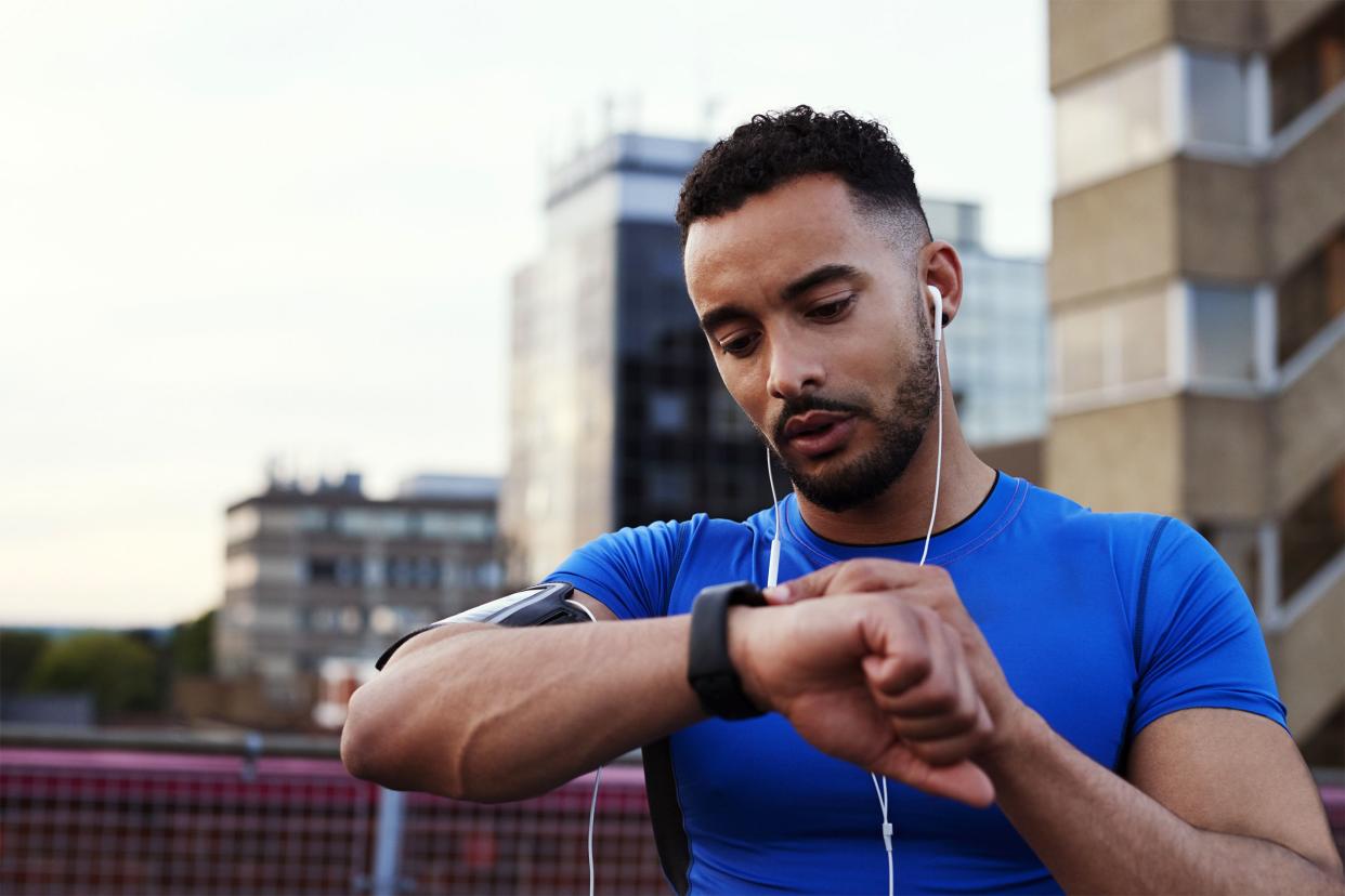 Man looking at watch before running