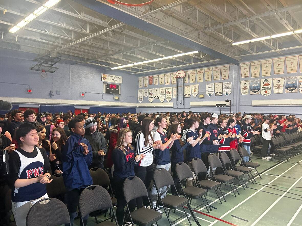 Students of Prince of Wales Collegiate in St. John's give a standing ovation to show support for their classmate.  (Mike Moore/CBC - image credit)