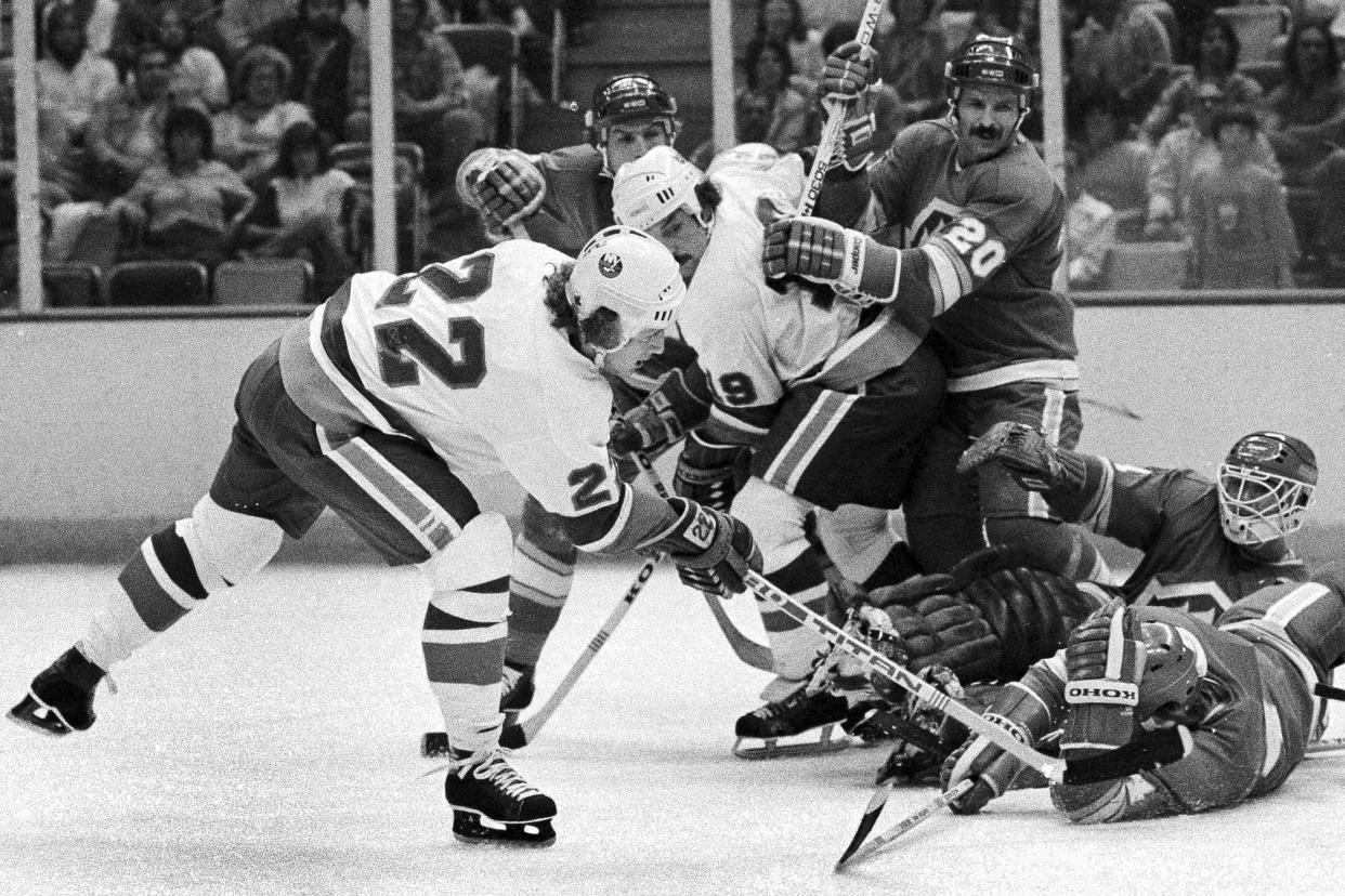 FILE - New York Islanders Mike Bossy, left, pushes the puck to the net to score against the Atlanta Flames, at the Nassau Coliseum in Uniondale, N.Y., Sept. 27, 1979. Bossy, one of hockey’s most prolific goal-scorers and a star for the New York Islanders during their 1980s dynasty, died Thursday, April 15, 2022, after a battle with lung cancer. He was 65. (AP Photo/Richard Drew, File)