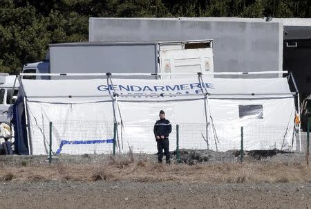 A French gendarme is seen near a tent during investigation into the crash of the Airbus A320 in Seyne-les-Alpes in French Alps March 27, 2015. REUTERS/Jean-Paul Pelissier