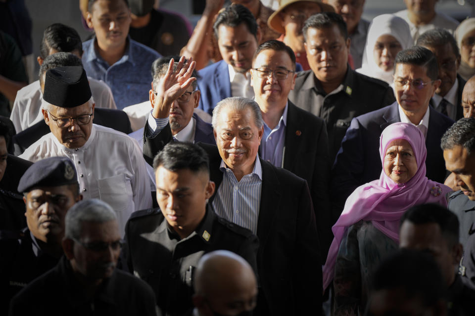Malaysia's former Prime Minister Muhyiddin Yassin, center, waves as he arrives at courthouse for a corruption charges in Kuala Lumpur, Malaysia, Friday, March 10, 2023. Muhyiddin, who led Malaysia from March 2020 until August 2021, will be the country's second leader to be indicted after leaving office. (AP Photo/Vincent Thian)