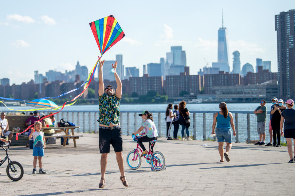 NEW YORK, NEW YORK - MAY 30: A person jumps trying to make a kite fly at Gantry Plaza State Park, Long Island City on May 30, 2020 in New York City. Government guidelines encourage wearing a mask in public with strong social distancing as all 50 US states have begun to slowly reopen after weeks of stay-at-home measures to control the spread of COVID-19.