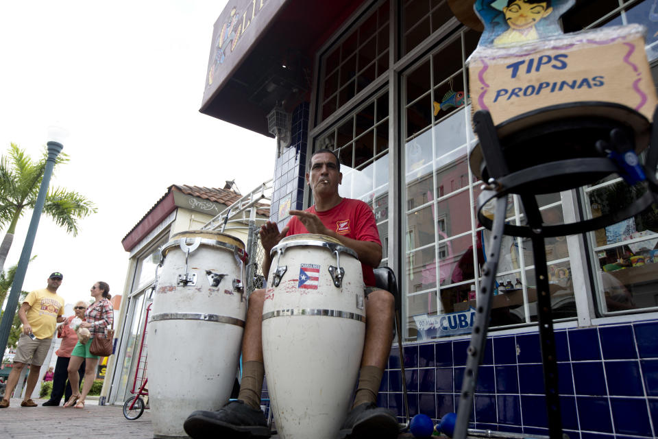 This April 30, 2014 photo shows Pablo Gonzalez Portilla playing Latin music on his drums outside a Cuban gift shop along Calle Ocho (Eighth Street) in Miami's Little Havana. Once a refuge for Cuban exiles rekindling the tastes and sounds a lost home, today Miami’s Little Havana is a mosaic of cultures and a popular tourist destination. (AP Photo/J Pat Carter)