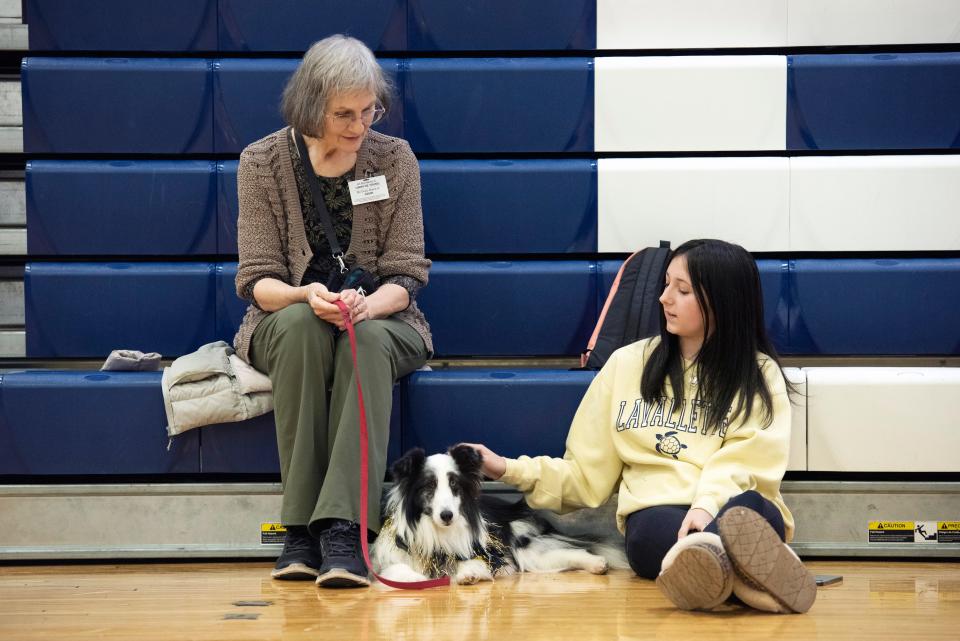 Handler Linda DeYoung introduces her therapy dog, Gavin, to student Viktoria Kulpa.