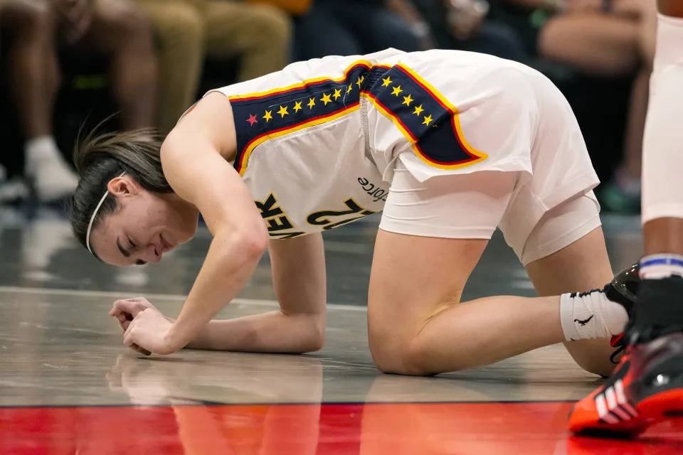 FILE - Indiana Fever guard Caitlin Clark (22) grimaces after being injured in the first half of a WNBA basketball game against the Connecticut Sun in Indianapolis, Monday, May 20, 2024. (AP Photo/Michael Conroy, File)