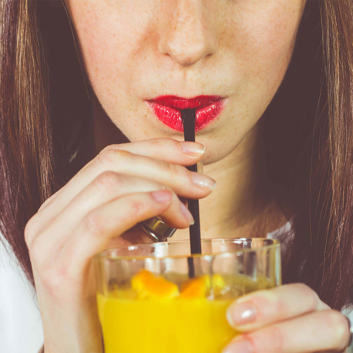 woman sipping on juice straw