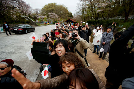 Well-wishers wave to Japan's Emperor Akihito and Empress Michiko as they visit Kodomonokuni in Yokohama, south of Tokyo, Japan, April 12, 2019. REUTERS/Issei Kato