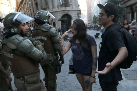 Mapuche indigenous activists argue with riot policemen near the government house during a protest demanding justice for Camilo Catrillanca, an indigenous Mapuche man who was shot in the head during a police operation, in Santiago, December 20, 2018. REUTERS/Ivan Alvarado