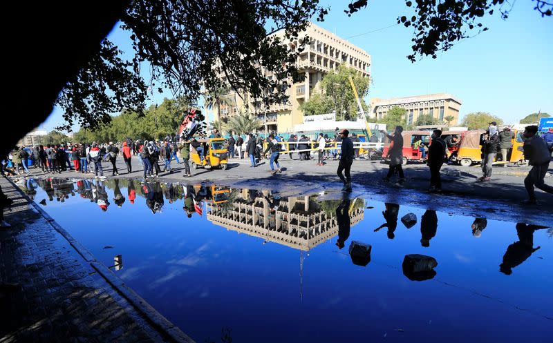 A reflection of Iraqi demonstrators is seen during ongoing anti-government protests in Baghdad